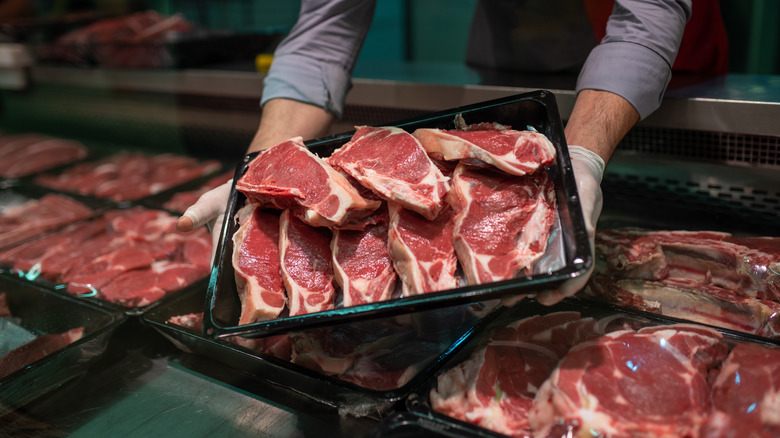 butcher holding meat in shop