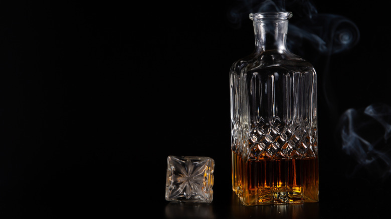 A whiskey decanter on a black background.