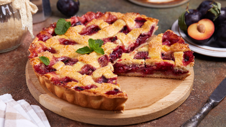 Plum pie with mint leaves and a slice cut out