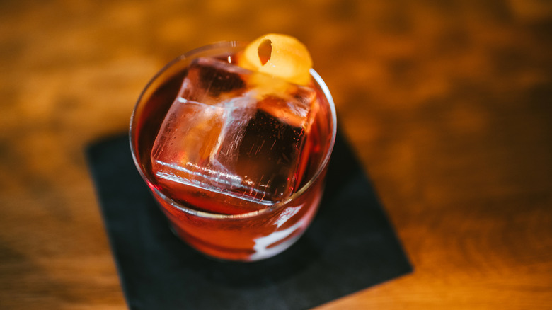 A negroni with a large ice cube in it, seen from above.