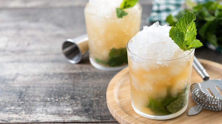Two mint julep drinks with crushed ice.