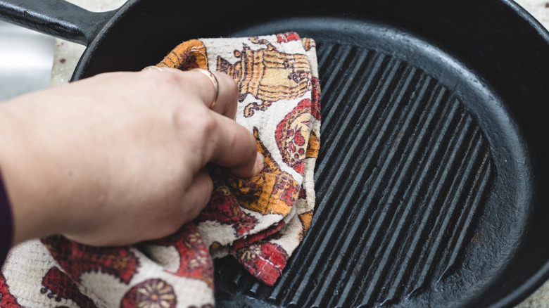 Drying a cast iron pan with a kitchen cloth