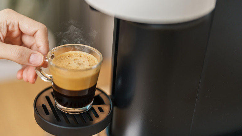Taking fresh espresso from a coffee machine