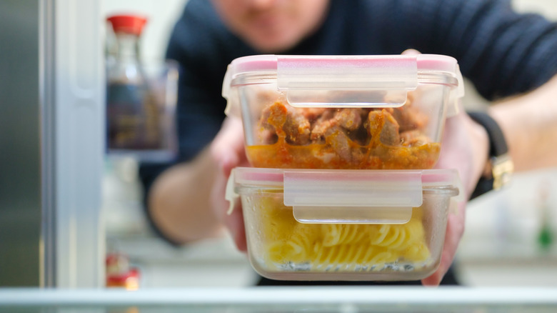 Person putting food back into the refrigerator