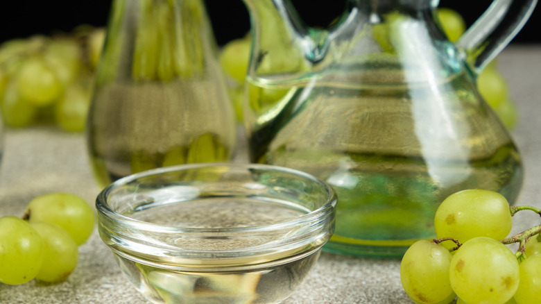 white vinegar in a bowl surrounded by grapes
