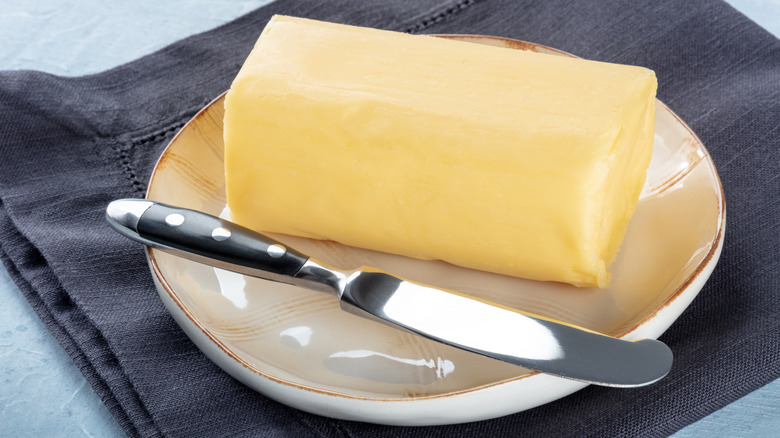butter knife next to butter on a plate