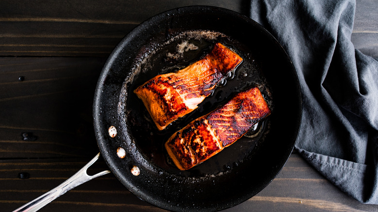 Seared salmon in a skillet.