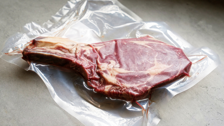 A vacuum sealed bone-in steak on counter.