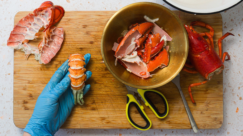 Hand holding lobster tail over board