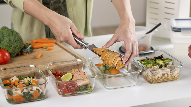 Person meal-prepping chicken