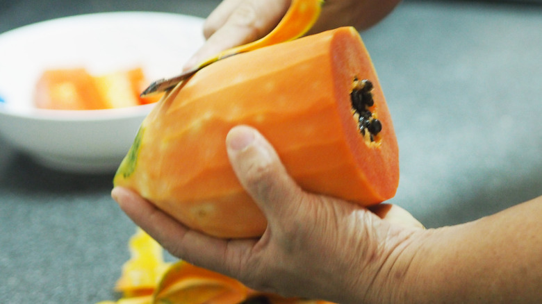 Peeling a papaya with a knife
