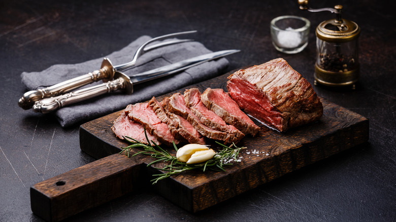 Sliced tenderloin on a wooden board.