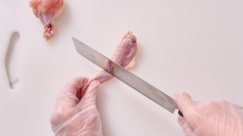 slicing between the wingette and wing tip with a knife