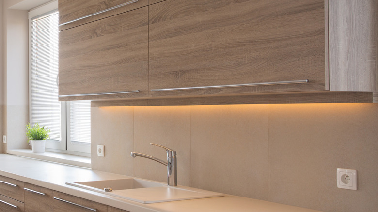 A wooden kitchen cabinet with under-cabinet lighting.