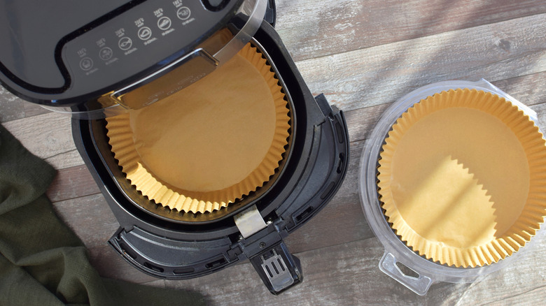 Air fryer next to a container of disposable liners.