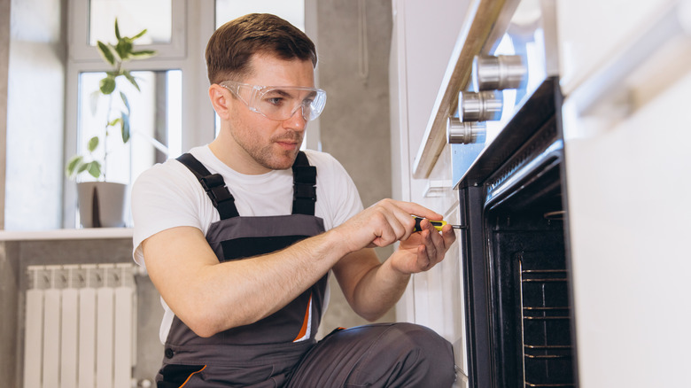 A man repairing an oven