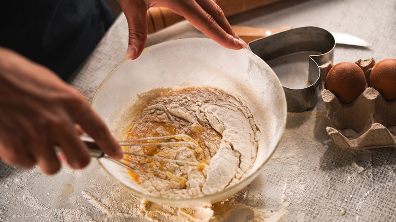 hands mixing batter in bowl