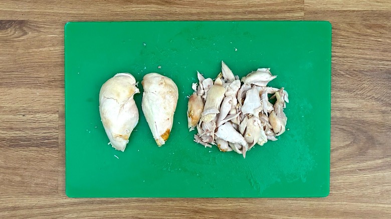 Deboned meat from a rotisserie chicken on a cutting board