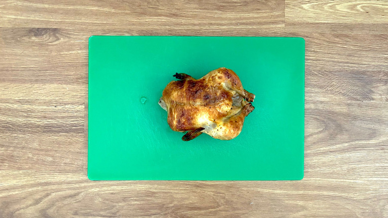 Whole rotisserie chicken on cutting board