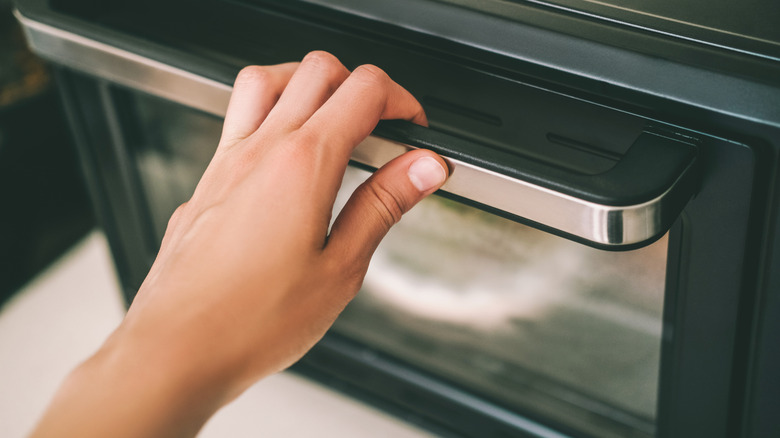 Hand on an oven door