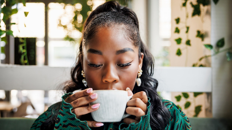 A young woman enjoying a hot cup of coffee