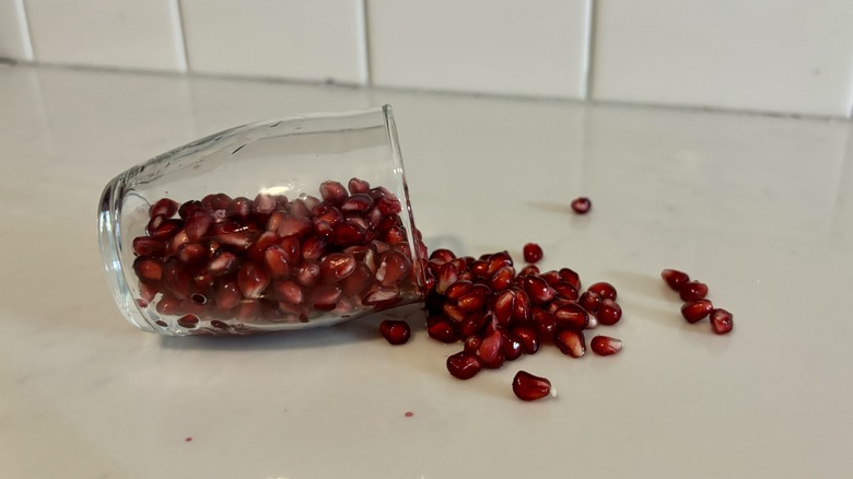 pomegranate seeds spilling from cup