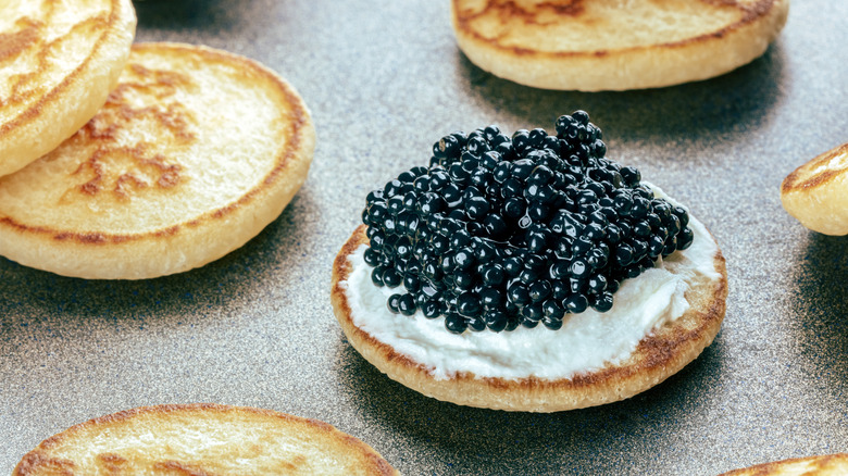 Black caviar on a blini with creme fraiche
