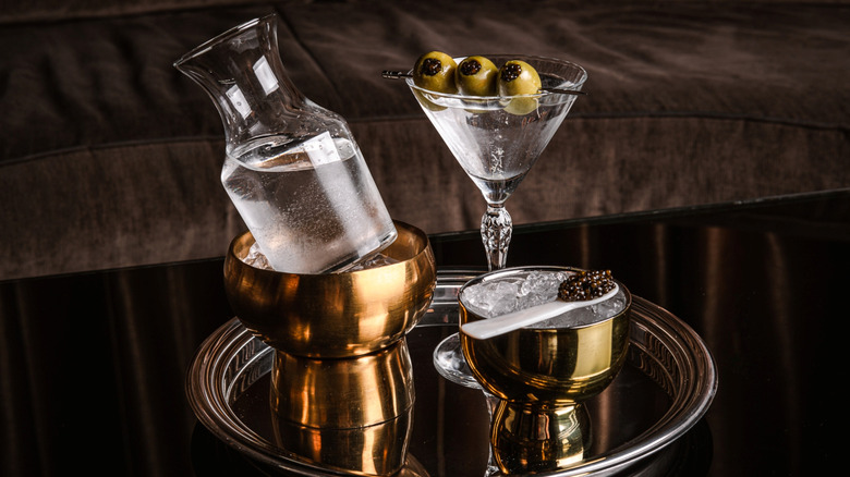 Two glasses of vodka on a tray with black and orange caviar
