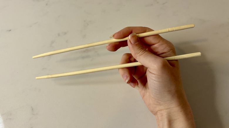 Hand holding chopsticks