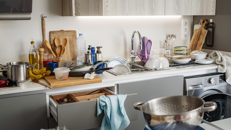 A cluttered kitchen with utensils everywhere