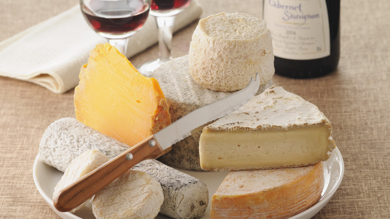 a variety of cheese stacked on a plate