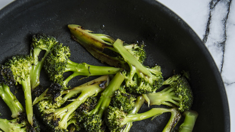 Simple diet meal, fried broccoli roses in a frying pan