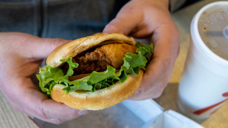 Hands holding Chick-fil-A sandwich