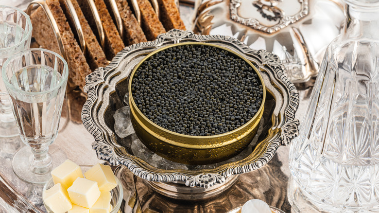Black caviar on ice in a silver bowl.