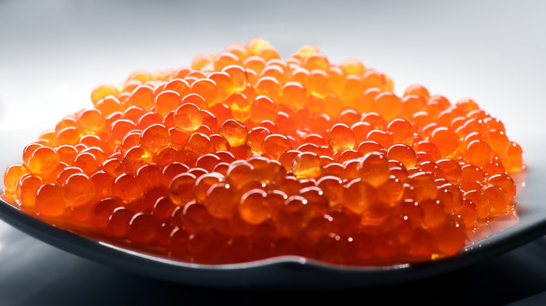 A close-up of red fish roe in a plate.