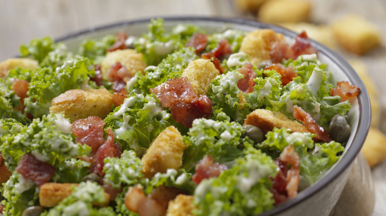 a salad with bacon bits and croutons