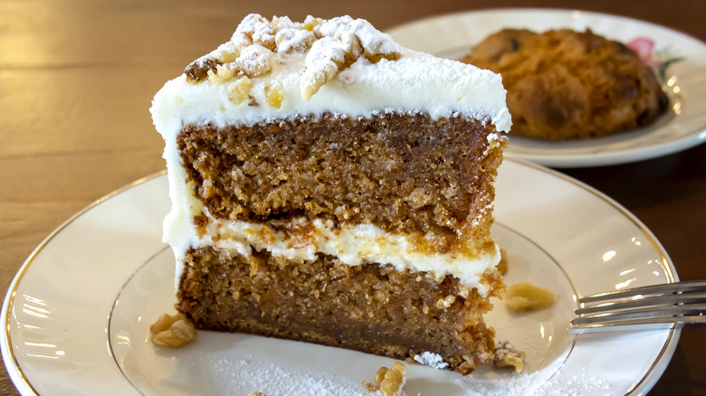 A tall slice of carrot cake on a plate.