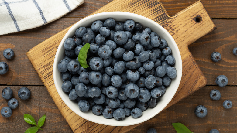 White ceramic bowl full of freshly picked blueberries
