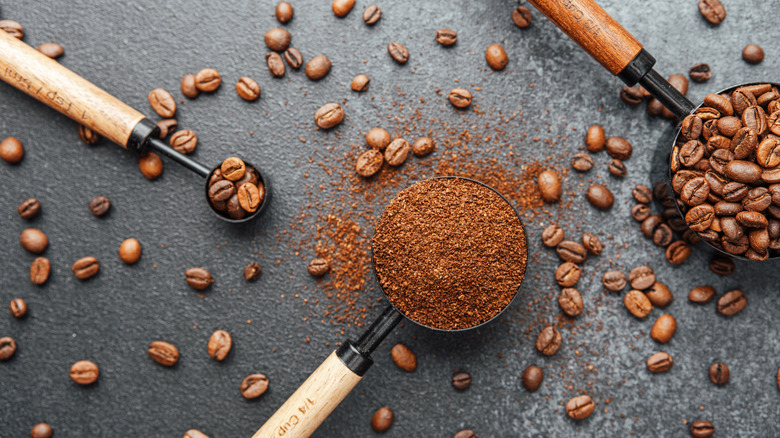 espresso powder in a measuring cup with coffee beans