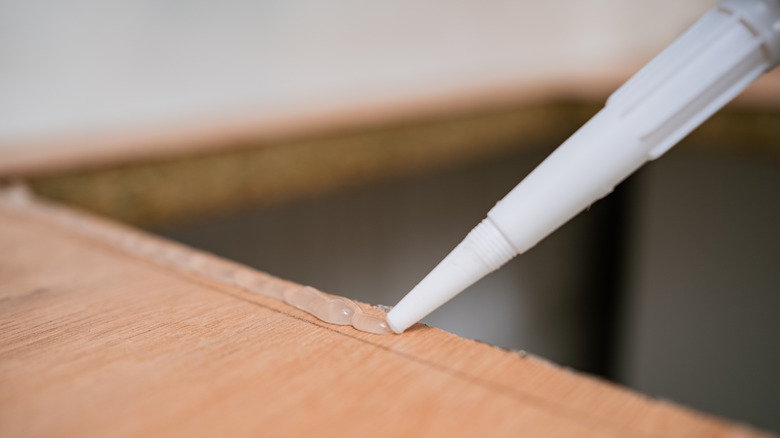 applying caulk on countertop for sink installation