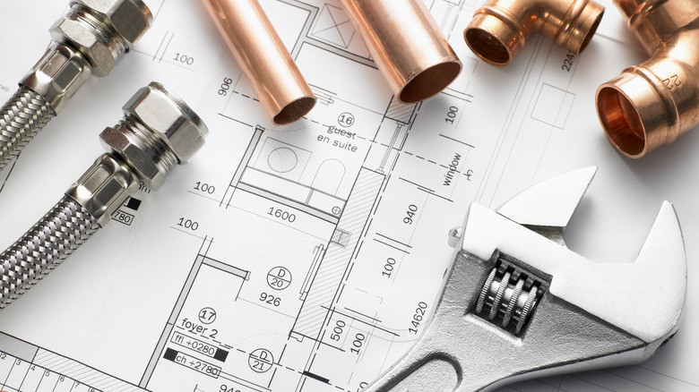 plumbing tools and fittings on blueprints