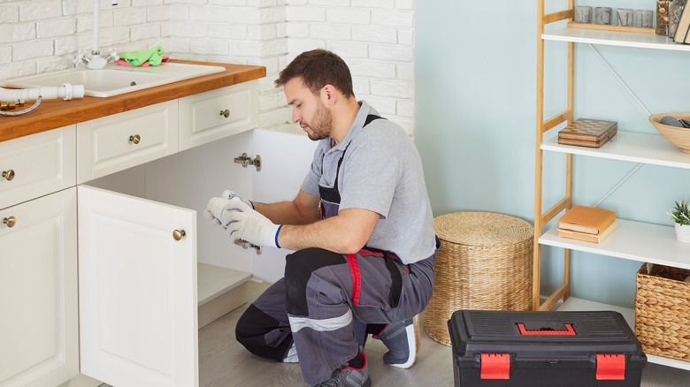 person working under sink