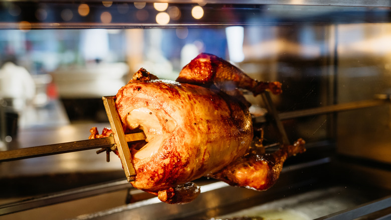 Rotisserie chicken turning on a spit.