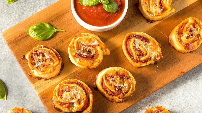 Homemade pizza rolls on a wooden serving board