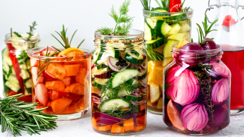 different vegetables being pickled in glass jars