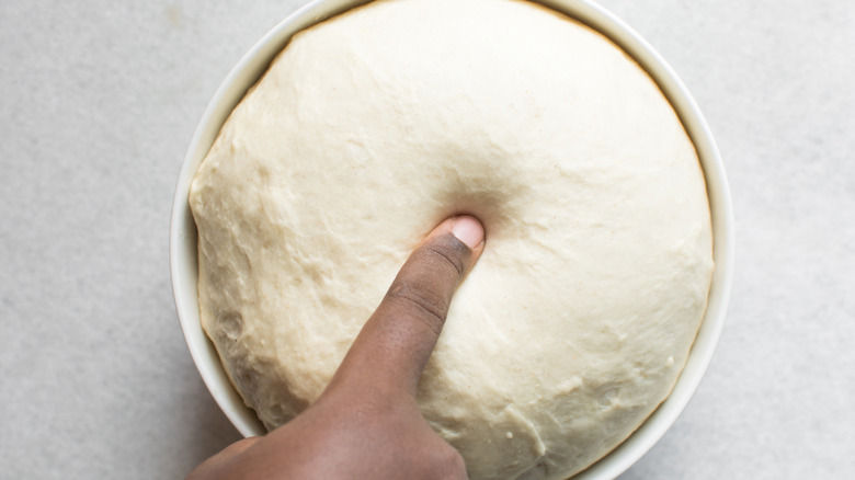 Person poking bread dough
