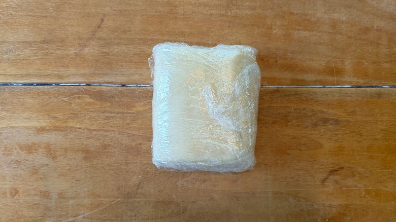 a wrapped paton dough on a wooden table