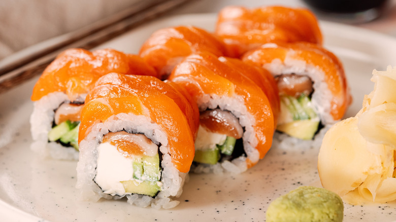 Philadelphia sushi roll set with salmon and cream cheese on plate.