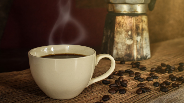 Cuban coffee with moka pot in the background.