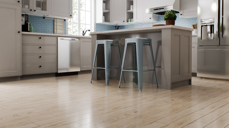 A modern style kitchen with gray cabinets, stainless steel appliances, and wood flooring.